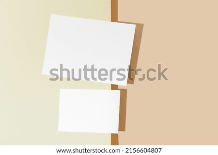 Two blank sheets of paper on color background