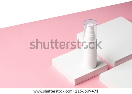 White plastic Bottle of cream with a dispenser on square podium and pink background. Mock up