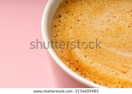 Coffee milk foam in cup. Background texture of cappuccino, closeup. Macro. Pink background Royalty-Free Stock Photo #2156609483
