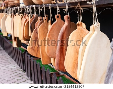 Market with wooden cutting boards from various types of wood - beech, oak, pine, spruce, ash, linden homemade products for cooking selective focus Royalty-Free Stock Photo #2156612809