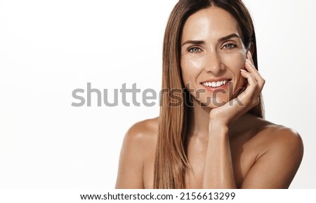 Beauty portrait of mature woman smiling with hand on face. Closeup face of happy adult, 40s years, woman feeling fresh after anti-aging treatment. Smiling beauty looking at camera with perfect skin Royalty-Free Stock Photo #2156613299
