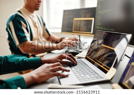 Closeup of two IT developers typing on keyboards while writing code at workplace in office, copy space Royalty-Free Stock Photo #2156623911