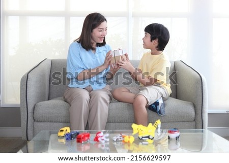 Boy and Mom sitting on sofa new house 