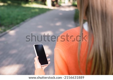 cropped view of woman holding smartphone with blank screen