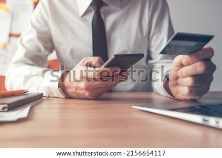 Mobile banking, businessman using smart phone and credit card for online financial transaction, close up with selective focus