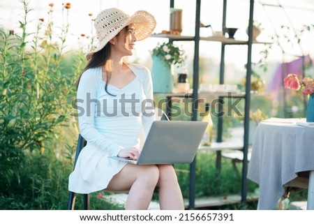 Young girls use laptops in the garden