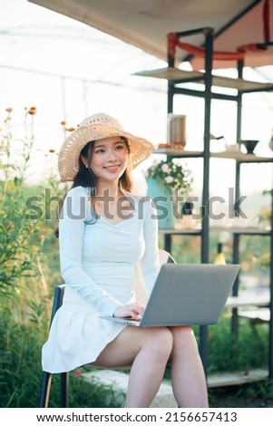 Young girls use laptops in the garden
