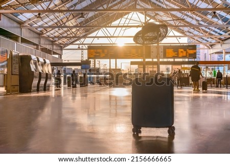 Detail of suitcase with hat, in train station, at sunset time. Horizontal photography, with copy space.