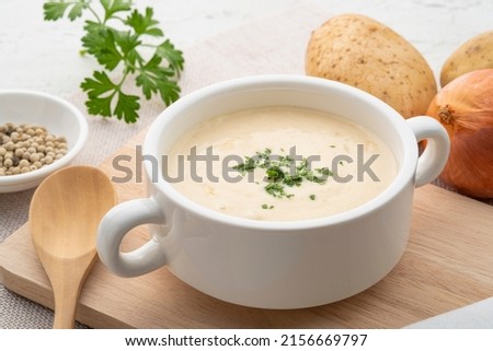 Bowl of creamy potato soup on wooden plate Royalty-Free Stock Photo #2156669797