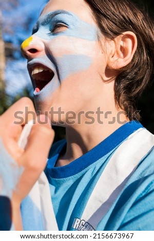 Argentinian soccer fan. Face painted encouraging the team of his country. Royalty-Free Stock Photo #2156673967