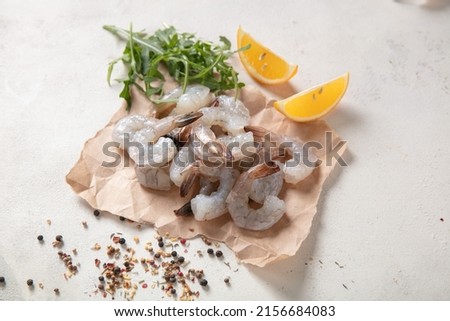 Fresh shrimp tails isolated. Raw headless prawn, pacific shrimp, uncooked tiger prawns, jumbo seafood on white background Royalty-Free Stock Photo #2156684083