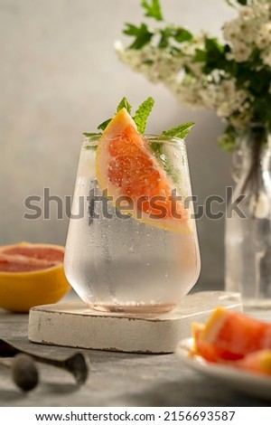 Refreshing, detox water summer drink with grapefruit, blooming brunch on background. Healthy lifestyle Royalty-Free Stock Photo #2156693587