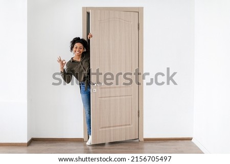 Happy African American Woman Gesturing Okay Opening Door Smiling To Camera Posing In New Home. Real Estate Owner Approving Offer. Apartment Renting And Purchase Concept