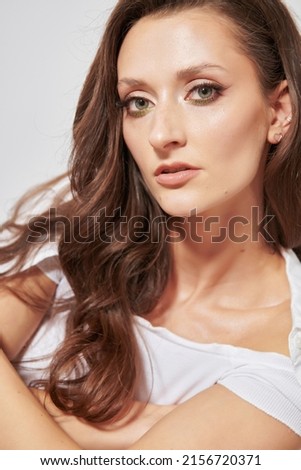 portrait of a girl with dark hair in white clothes on a white background