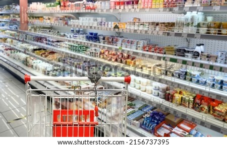 choosing a dairy products at supermarket.empty grocery cart in an empty supermarket Royalty-Free Stock Photo #2156737395