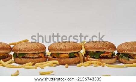 Classic fast food menu set from burgers and french fries. Unhealthy eating. High-calorie tasty and appetizing sandwiches from meat, cheese, vegetables and sauce. White background in studio. Copy space
