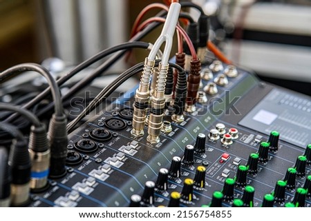 Sound audio mixer. General plan of sliders and buttons on a mixing console with connected audio jacks Royalty-Free Stock Photo #2156754855