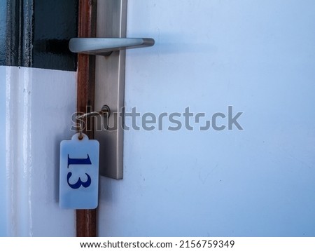 Close up of the keyhole of room 13 with the key inside on the wooden door. 