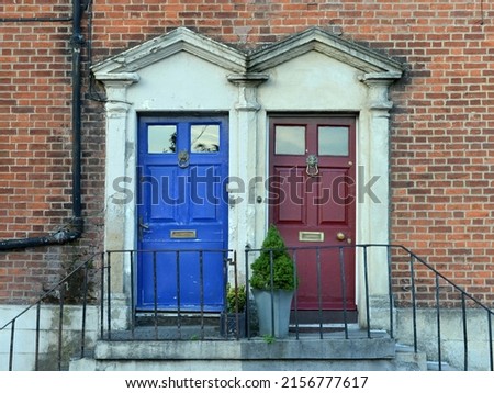 Front doors of two neighbouring town houses on a street in an English city Royalty-Free Stock Photo #2156777617