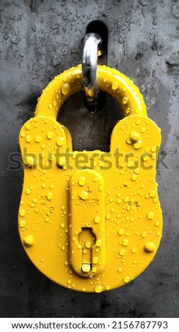 A yelllow lock on gray door