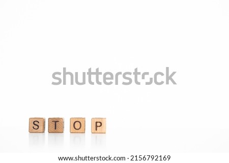 Stop word written on wooden blocks on wooden table. Concept for your design