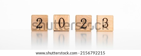 Wooden cubes with text 2023 written in black on a wooden block surface. Happy New Year concept