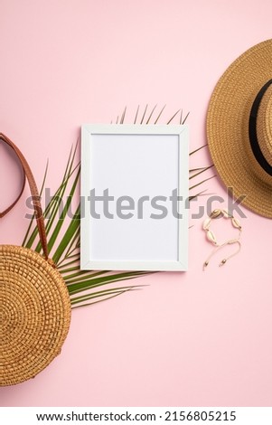 Summer vacation concept. Top view vertical photo of white frame sunhat round rattan bag shell bracelet and palm leaves on isolated pastel pink background with empty space