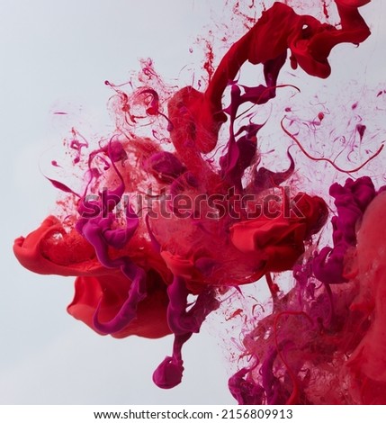 Explosion of paint in water over gray background