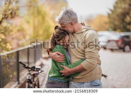 Teenage daughter hugging her father outside in town when spending time together. Royalty-Free Stock Photo #2156818309