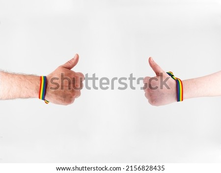 
hands with bracelets with the lgtbi flag, support