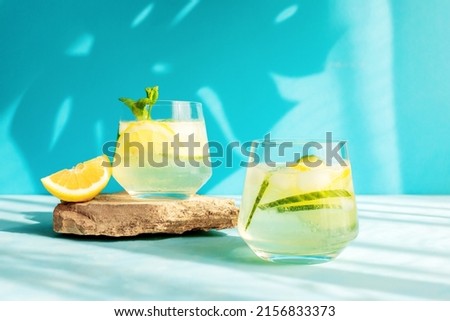 Summer detox refreshing drink or alcoholic cocktail with lemon slices and ice, garnished with a sprig of mint. Chilled water with lemon. Healthy drinks Royalty-Free Stock Photo #2156833373