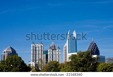 The city skyline against a blue sky over trees