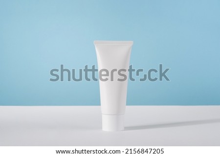Moisturiser hand cosmetic cream white plastic tube mockup on blue background front view. Blank body and health care beauty product packaging. Hand cream bottle Royalty-Free Stock Photo #2156847205