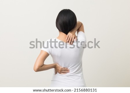 Asian woman has problem with structural posture She had neck and back pain. She massaged her neck and shoulders for relief. reduce muscle tension. Standing on isolated white background Royalty-Free Stock Photo #2156880131