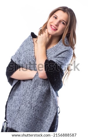 Beautiful young woman in a winter plaid. Winter fashion model. Attractive beautiful young woman wrapped in a warm plaid in winter. Studio photo. Woman isolated on white background.