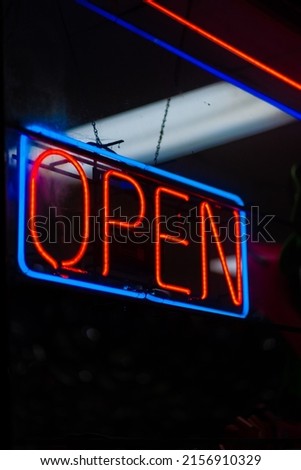 A vertical shot of a neon open sign