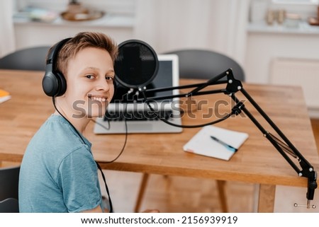 schoolboy sits in front of his laptop and records a podcast