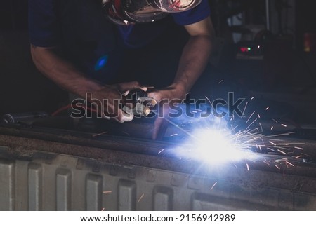 A welder welding automotive part in a car factory