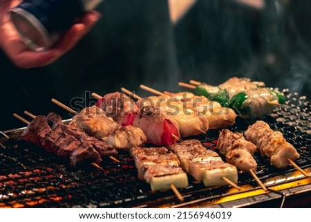 Yakitori Barbeque (BBQ) being grilled by street food store in Shinjuku, Tokyo, Japan. Royalty-Free Stock Photo #2156946019