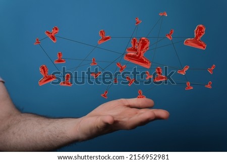 A hand holding illustrative people icons connected together - the concept of communication 