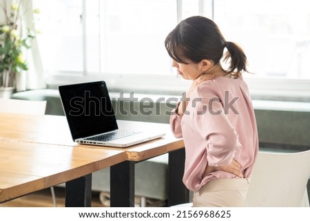 Business woman suffering from stiff shoulders Royalty-Free Stock Photo #2156968625