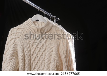 Hanger with white warm sweater –black background