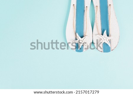 Blue colored summer and vacation background, slippers with sea stars, copy space for text, holiday and tourism concept