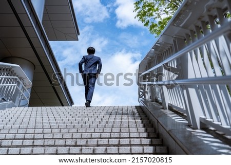 A man in a suit walking in a business district Royalty-Free Stock Photo #2157020815