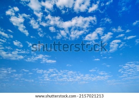 Summer sky. White clouds in the blue sky. Heaven and infinity. Beautiful bright blue background. Light cloudy, good weather. Curly clouds on a sunny day. Royalty-Free Stock Photo #2157021213