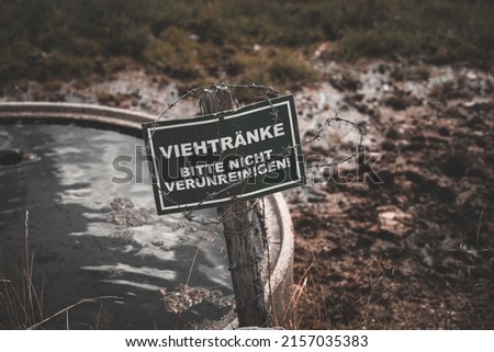 A closeup shot of the german sign for not contaminating cattle troughs