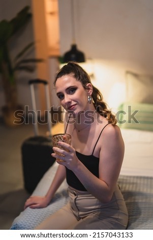 a vertical shot of girl drinking juice on bed
