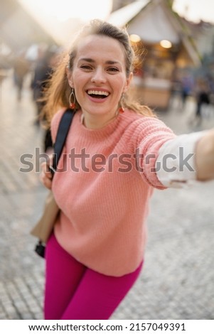 happy modern 40 years old woman at the fair in the city taking selfie.