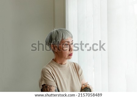 Portrait of an old woman of rumination, anxiety, feeling depressed, discouraged, bored, unhappy, looking at a window. Amnesia Alzheimer's disease Mental disorders of the elderly. elderly health concep Royalty-Free Stock Photo #2157058489
