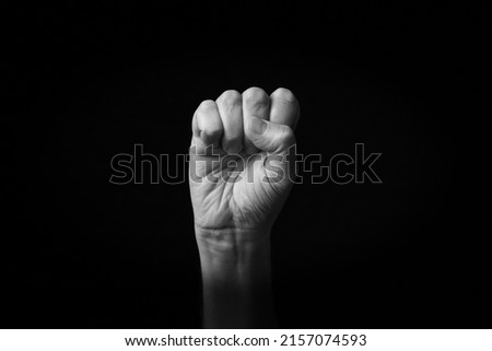 Dramatic black and white image of Raised Fist emoji isolated on black background